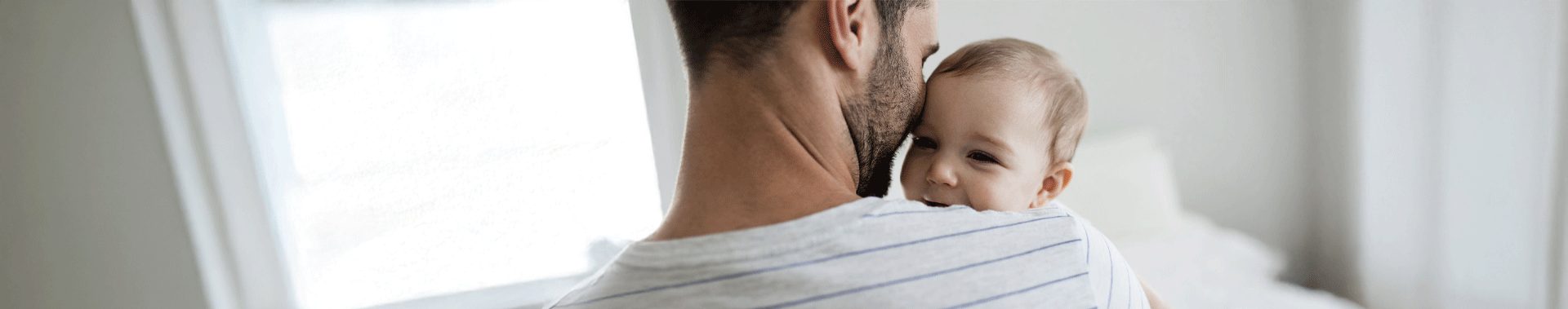 dad holding smiling baby